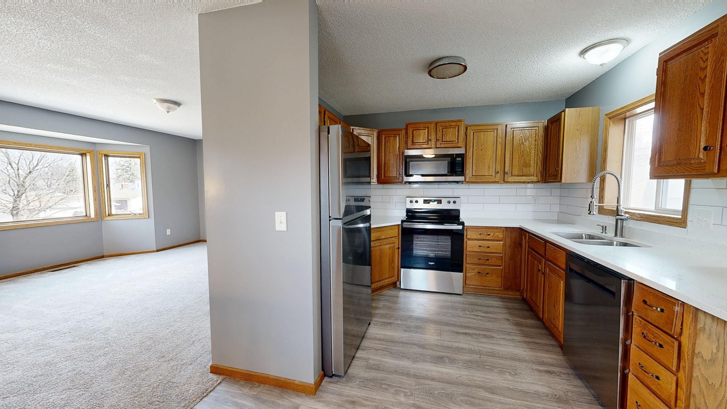 Bright modern kitchen and living space showing the polished result of a home renovation.